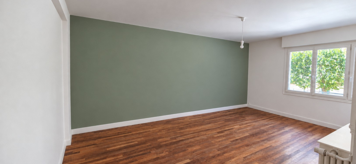 Séjour avec mur vert sauge et plafond blanc après peinture